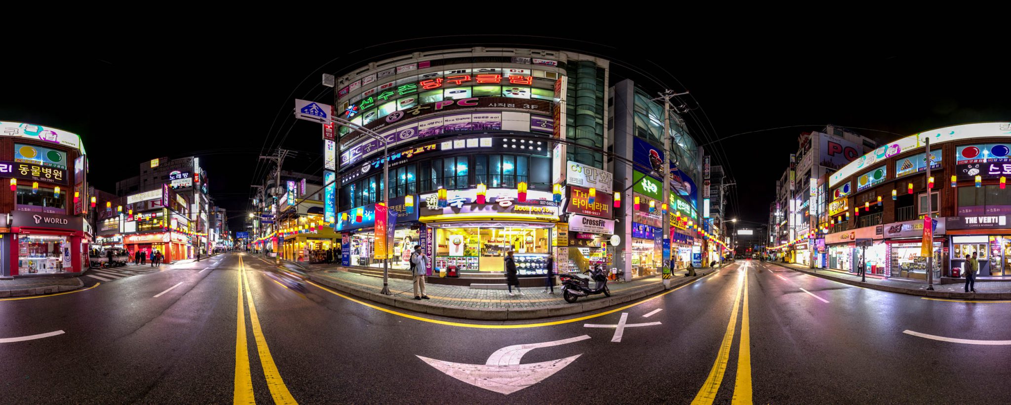 360 photo from the middle of a street lined with shops with brightly coloured signs and advertisments in South Korea.