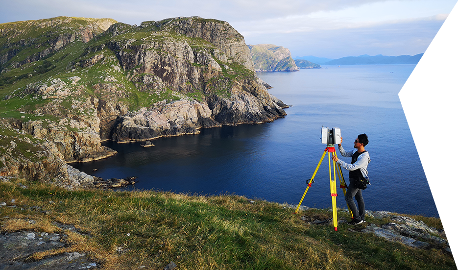 Clear Angle crew member with a Leica P40 on top of a cliff with the ocean in the background, capturing a Lidar scan of the environment